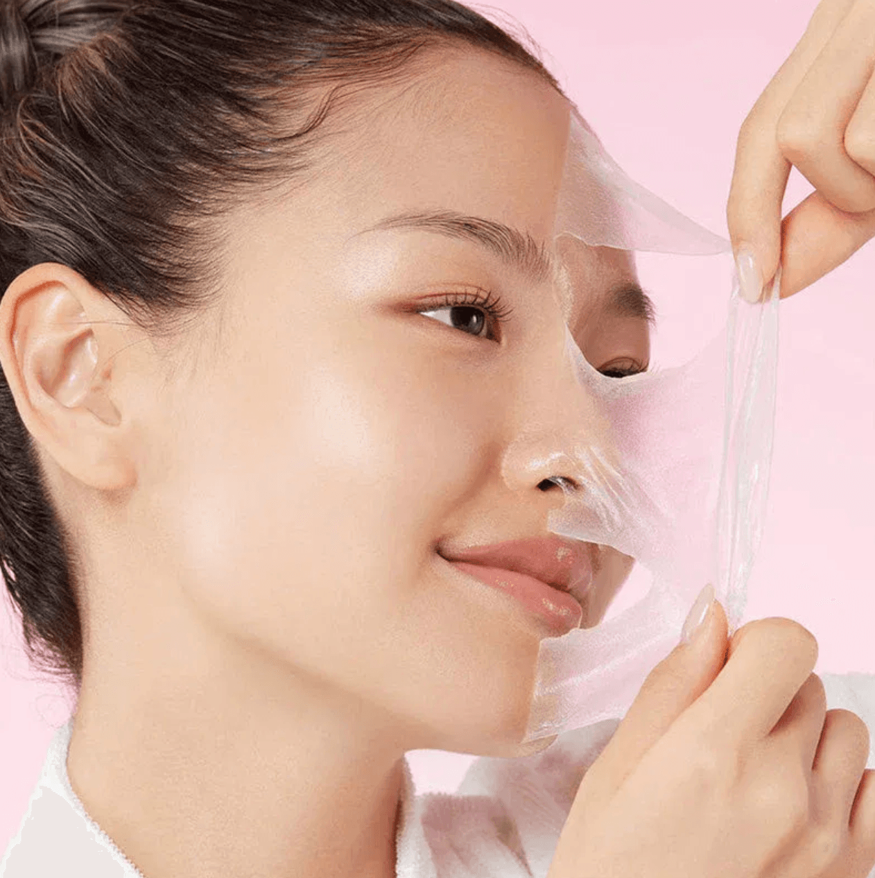 Model peeling a translucent Korean facial mask from her skin
